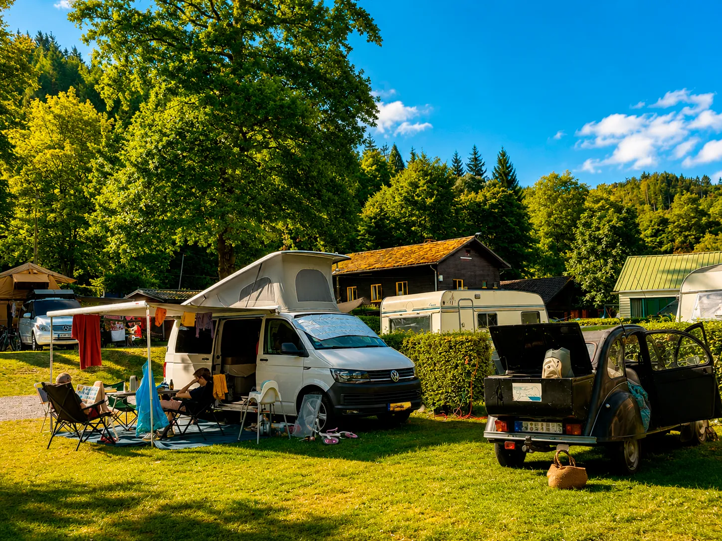 Van aménagé et 2CV installés sur un emplacement du camping